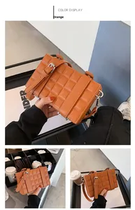 Close-up of orange box bag featuring waffle textured faux leather and adjustable strap