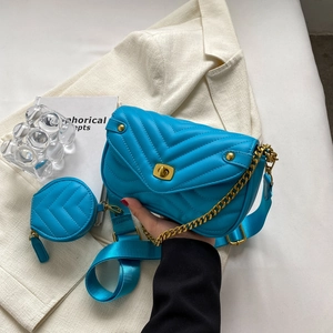 Détail du sac à main matelassé bleu roi avec garniture dorée et petit porte-monnaie assorti