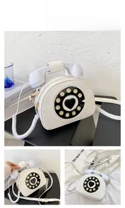 Detail of creative vintage white telephone shaped handbag with rotary dial and handset handle