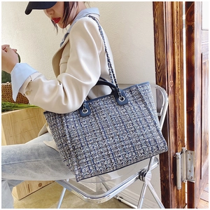 Close-up of tricolor tweed bucket bag with leather chain strap on a model
