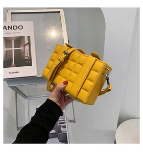 Detailed close-up of yellow quilted box bag showing soft texture and silver hardware