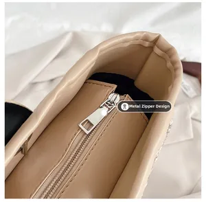 Close-up of the metal zipper design and interior lining of the beige leather bucket bag