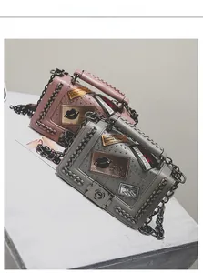 Detailed shot of retro crossbody bags with fashion patches, metal studs and chain straps