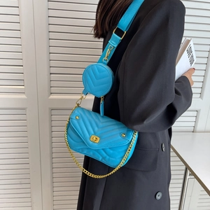 Détail du sac bandoulière bleu vif à surpiqûres en V avec mini porte-monnaie et chaîne dorée