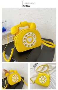 Detail of yellow creative vintage telephone-shaped crossbody bag with dial pattern