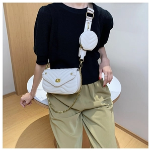 Gros plan d'un sac bandoulière blanc matelassé avec sangle large et mini pochette