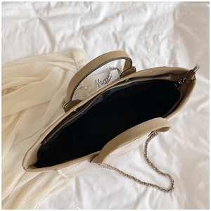 Internal view of large straw tote bag with zipper closure and brown leather handles