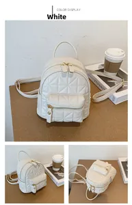 Detailed close-up showing white quilted mini backpack with gold zippers and chain straps