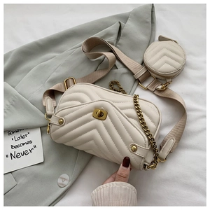 Sac matelassé beige avec fermoir rotatif doré et bandoulière large en tissu détaillée