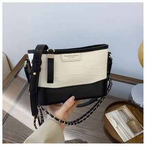 Detail of black and white contrast bucket bag with crocodile texture and dual straps
