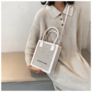 Minimalist white crossbody bag with woven texture worn by model on shoulder