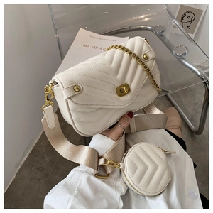 Détail du sac matelassé crème avec chaîne dorée et petit porte-monnaie amovible
