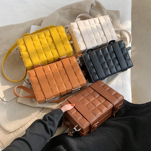 Detail of five mini box bags in various colors featuring embossed checkered texture