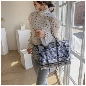 Close-up of geometric ethnic woven tote bag with blue and white contrast pattern