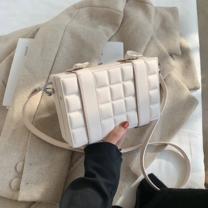 Detailed close-up of cream box bag showing 3D checkered texture and leather straps
