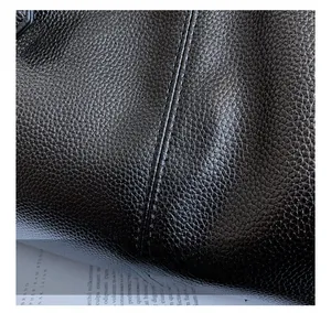 Macro detail of high-quality black lychee leather with professional stitching craftsmanship