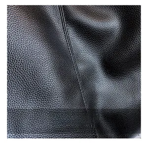 Close-up of premium black lychee grain PU leather texture showing soft natural patterns