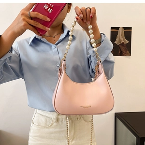 Détail du sac hobo rose avec poignée en perles décorative et bandoulière chaîne dorée