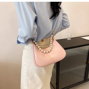Détail du sac hobo rose avec bandoulière en perles et texte en cuir embossé