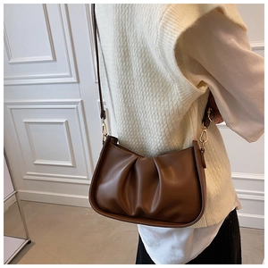 Détail d'un sac nuage plissé marron foncé avec bandoulière fine et crochets dorés