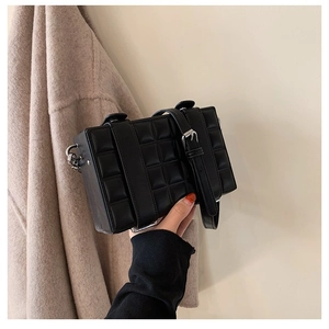 Minimalist black box crossbody bag with textured checkered pattern and silver hardware buckle