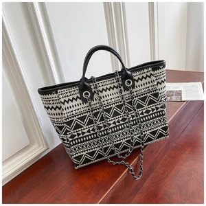 Macro detail of weave texture and black leather handle on ethnic geometric tote bag