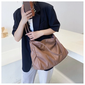 Brown soft PU leather tote bag shown on model for daily commuting and large capacity use