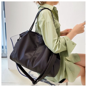 Close-up of a large dark brown PU leather tote bag with pebbled texture and wide strap