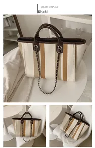Macro shot of khaki striped canvas tote bag with brown leather chain strap details
