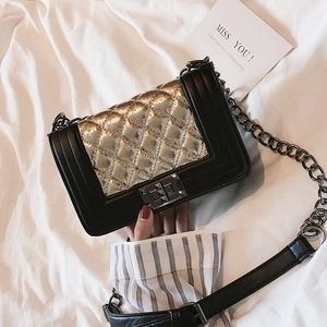Detail of quilted leather crossbody bag featuring silver metallic finish and metal lock
