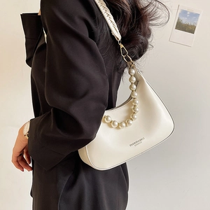 Sac hobo blanc en demi-lune avec chaîne en perles et bandoulière sur blazer noir