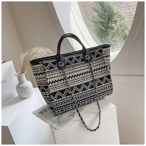 Close-up of ethnic geometric print tote bag with leather handle and metal chain strap