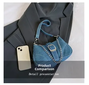 Blue denim crossbody bag detail with silver buckle and chain shown next to a phone