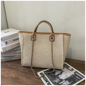 Macro view of woven tote bag texture with brown faux leather trim and chain details