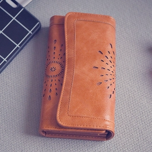 Dettaglio del portafoglio lungo marron vintage con motivi floreali traforati al laser