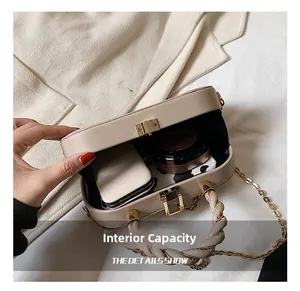 Macro detail of beige box bag showing internal capacity for phone and makeup