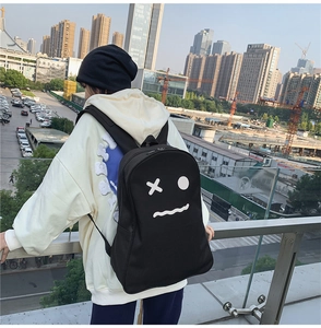 Photo street style d'un sac à dos en toile noire avec un visage de fantôme blanc épuré