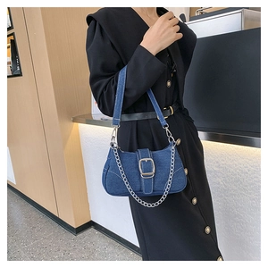 Detail of blue denim shoulder bag with silver chunky chain and metal buckle closure