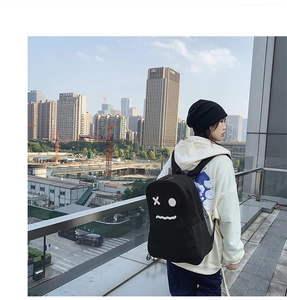 Photo de rue d'un sac à dos noir avec un motif fantôme créatif sur un mannequin femme