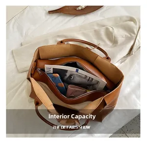 Intérieur spacieux d'un grand cabas marron en cuir avec rangement pour magazines et mobile