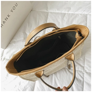 Top view of woven tote bag showing spacious interior with metal zipper and chain strap
