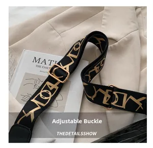 Close-up of adjustable fabric shoulder strap with golden geometric patterns and metal buckle