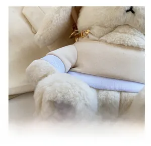 Détail du sac lapin en peluche avec tricot blanc et chaîne métallique dorée élégante