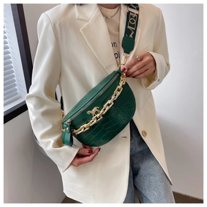 Detail of green crocodile texture waist bag with thick gold chain and horse buckle