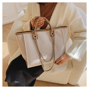 Elegant bucket bag in cream canvas and brown leather trim with silver chain details