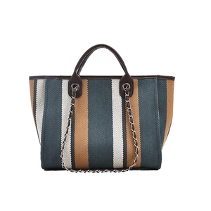 Large striped woven tote bag with brown leather handles and silver chain detail for women