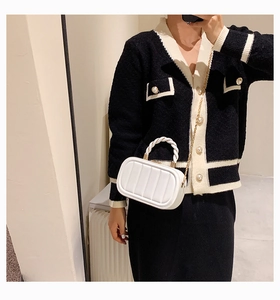 Close-up of white quilted mini bag with woven top handle and gold chain strap