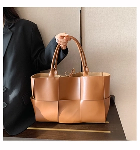 Détail d'un grand sac cabas tressé marron en similicuir avec texture à carreaux et lacet