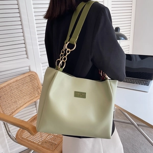 Detail of mint green tote bag featuring chunky metal chain strap and logo patch