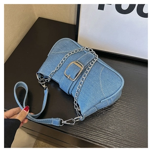 Close-up of light blue denim crossbody bag featuring silver metal chain and hardware details